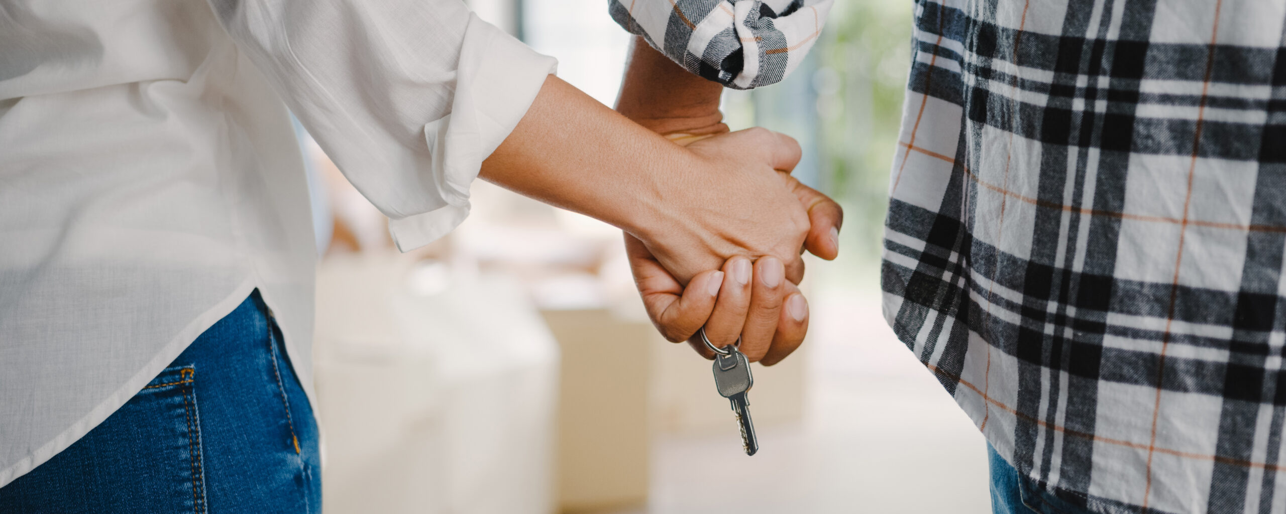 Happy African American young family bought new house. Young married couple wife and husband hold keys having fun laugh into modern home. New real estate dwelling, loan and mortgage.